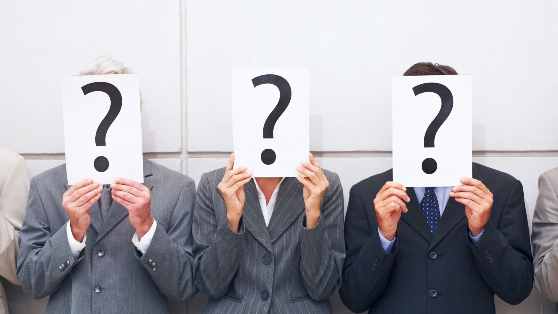 business people covering faces with question mark poster